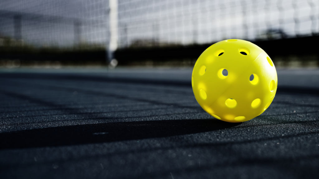 yellow pickleball on outdoor court