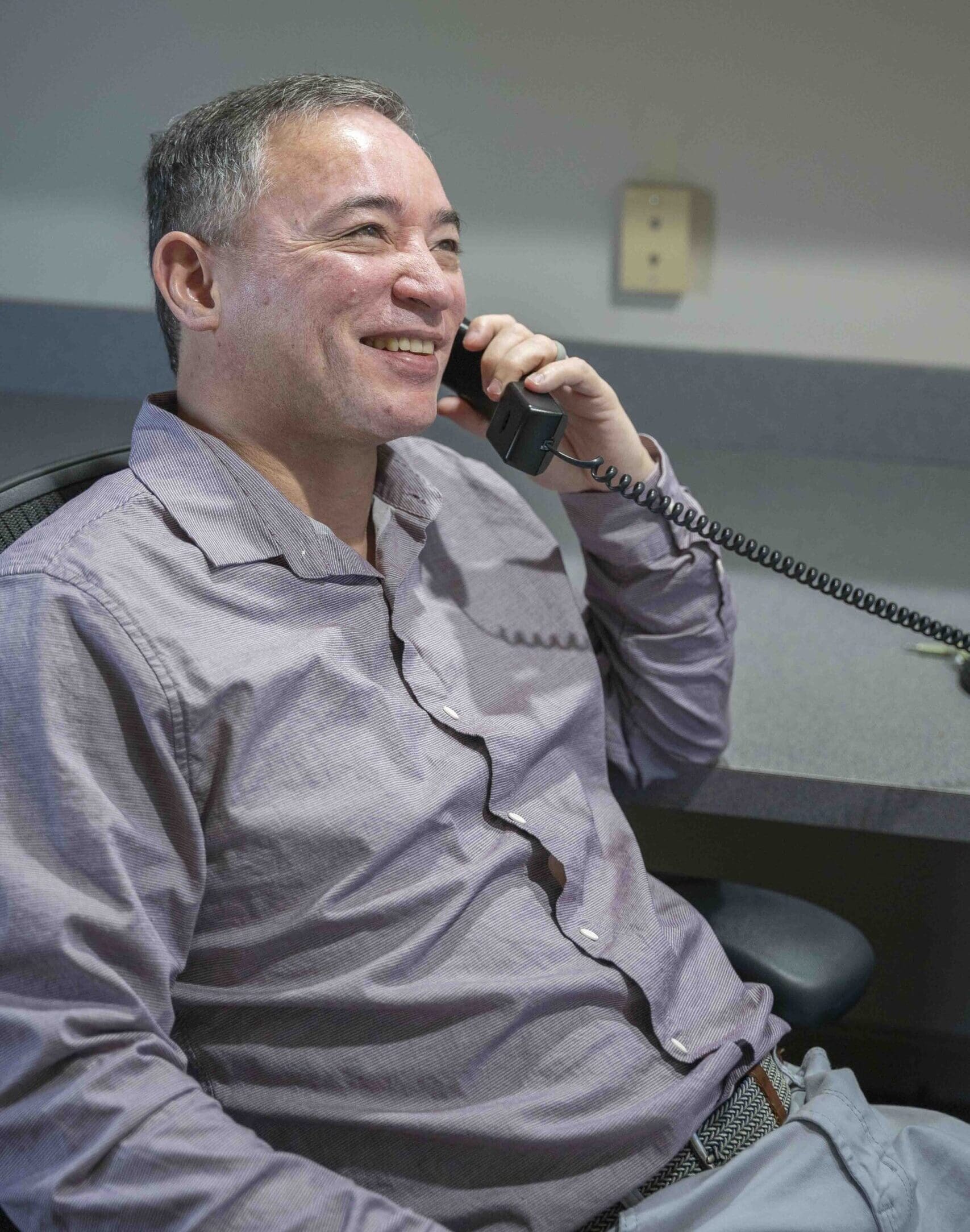 man speaking on telephone and smiling