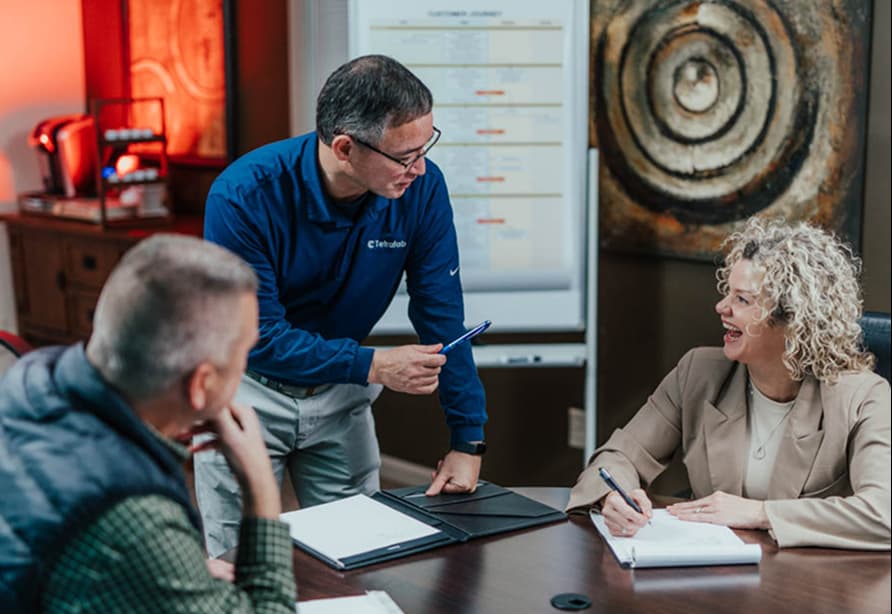two men and a woman in a business meeting engaged in discussion